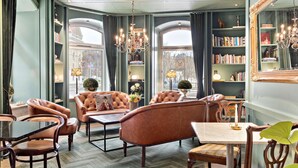 A room with leather sofas, a chandelier, bookshelves, and a large mirror. - Best Western Plus Hotel Baltic (Sundsvall)