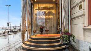 A hotel entrance with a glass door, outdoor seating area, and steps leading to the entrance. - Best Western Plus Hotel Baltic (Sundsvall)