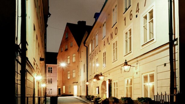 A narrow street lined with historic buildings, including a hotel with the name "Hotel Anno" visible on its facade. - Anno 1647 (Stockholm)