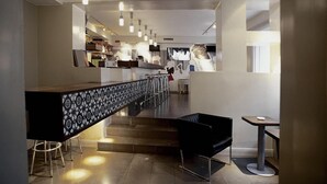 A modern interior with a bar area, seating, and a staircase. - Anno 1647 (Stockholm)