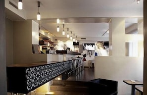 Ein modernes Interieur mit Barbereich, Sitzgelegenheiten und einer Treppe.