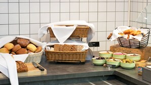 A buffet with various breads, pastries, and condiments. - First Hotel Brommaplan (Bromma)