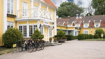En gul byggnad med en skylt som visar att det är en restaurang. Det står cyklar parkerade framför.