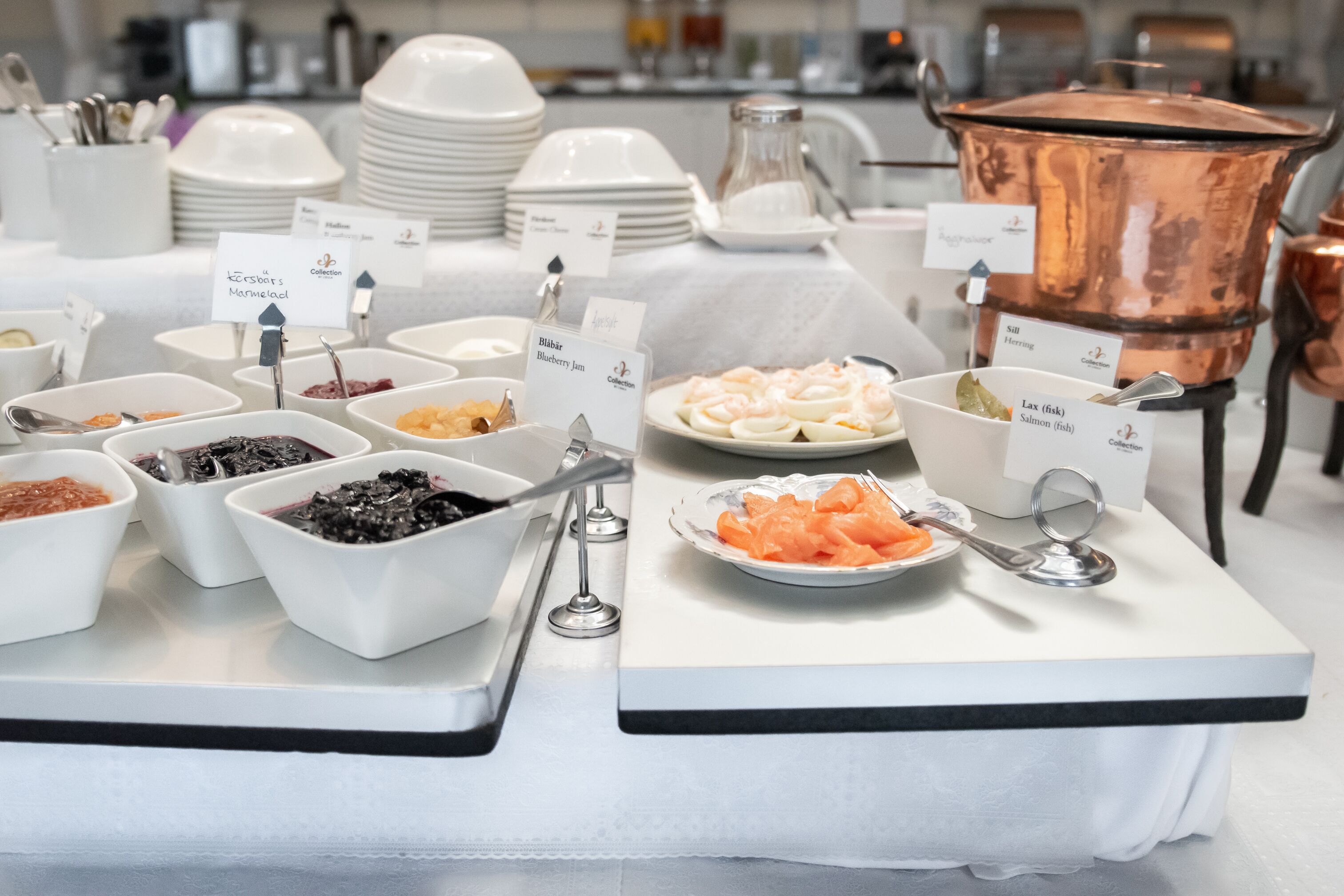 Una mesa de buffet con diversos alimentos y recipientes etiquetados.