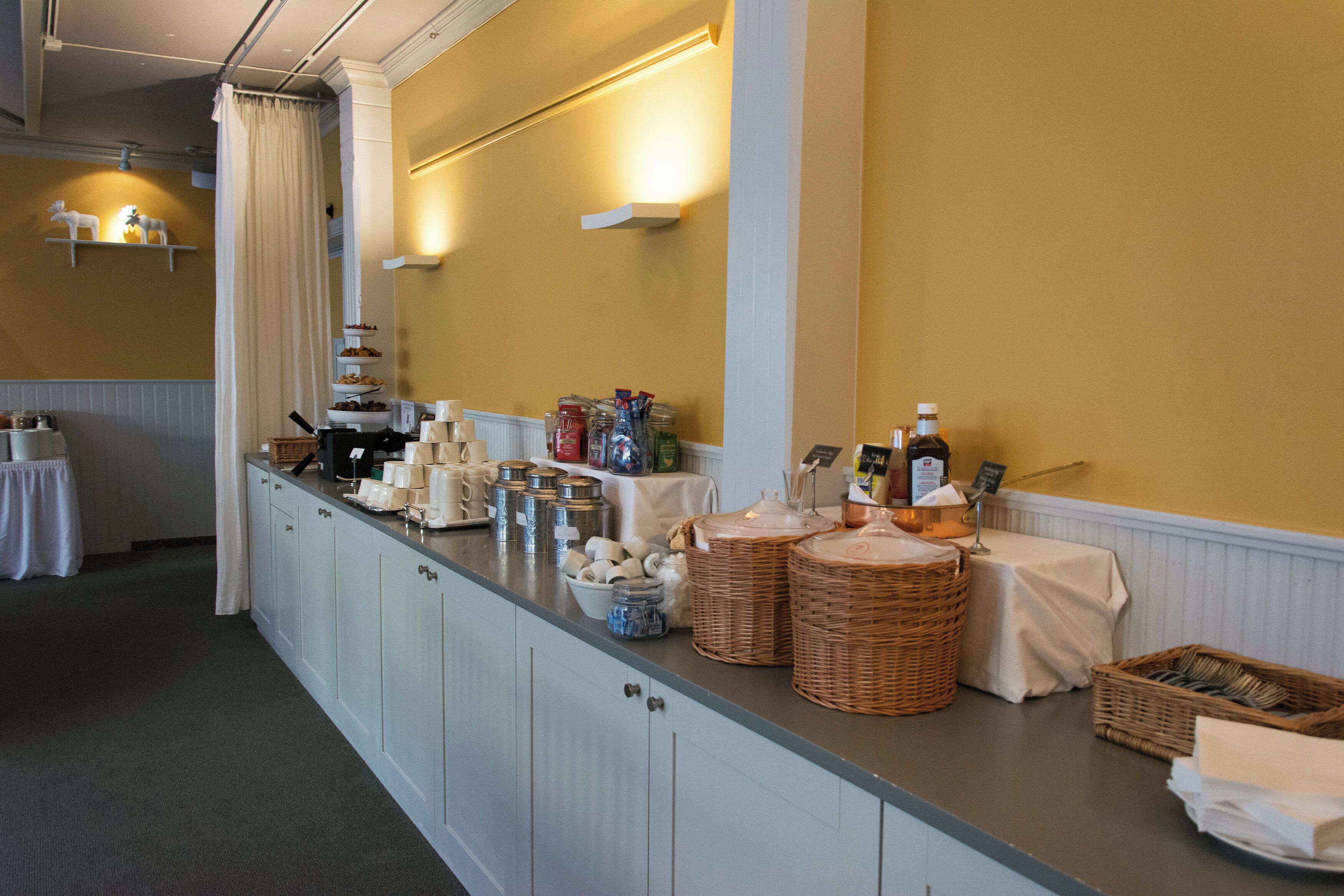 Una barra de buffet con diferentes alimentos, cestas y aderezos.