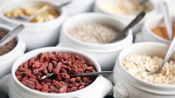 Diversos alimentos en cuencos blancos con cucharas.