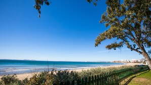 A coastal view with a beach, a fence, and a tree. - Hotel Roses Platja (Roses)