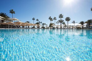 A clear blue pool with lounge chairs and umbrellas, surrounded by palm trees. - Grand Hyatt Lanzarote Playa Dorada Resort (Yaiza)
