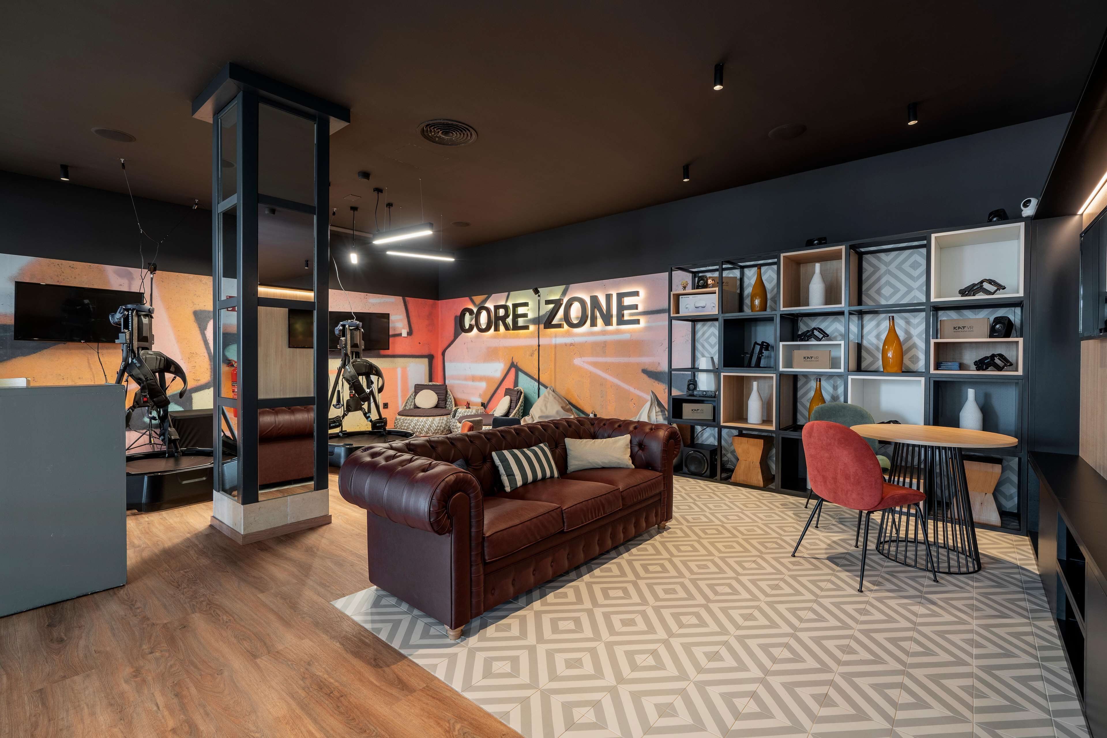 Un interior moderno con un sofá de cuero, una silla roja y un letrero que dice 'CORE ZONE'.