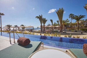 A pool area with lounge chairs, umbrellas, and palm trees. - Grand Hyatt Lanzarote Playa Dorada Resort (Yaiza)