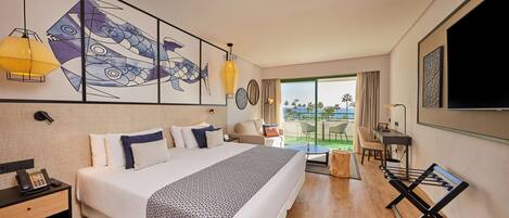 A modern hotel room with a large bed, a desk, a chair, and a view of the outdoors.