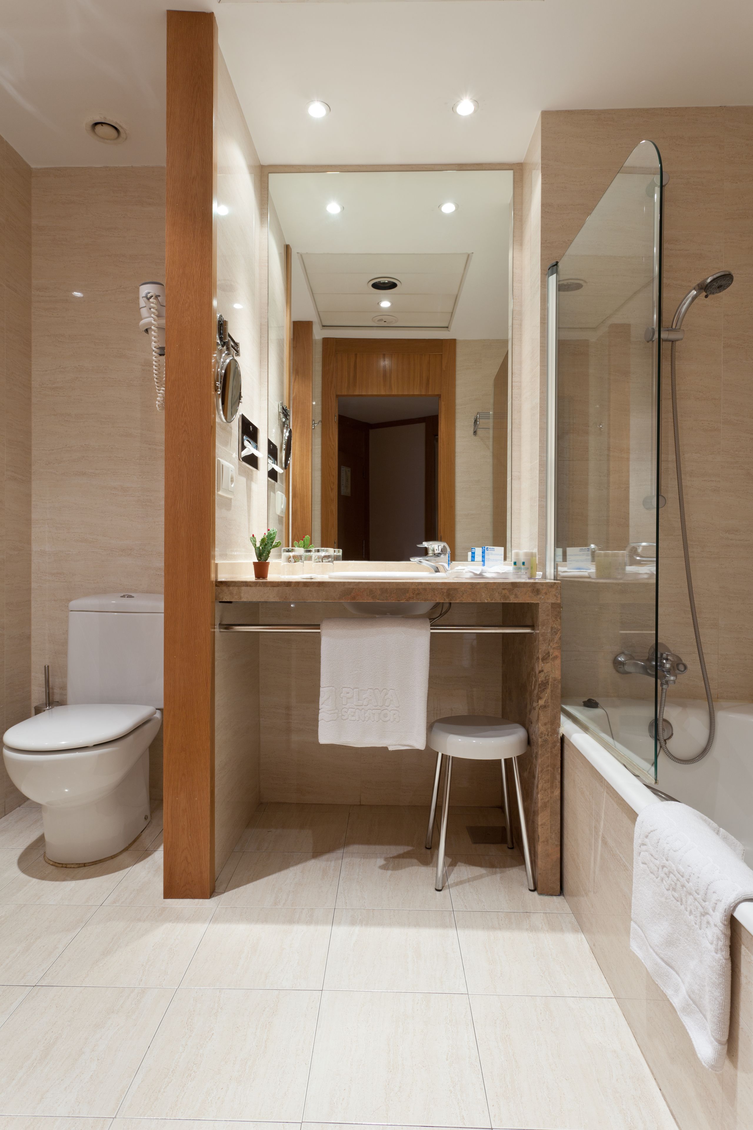 Un baño moderno con inodoro, lavamanos y ducha.
