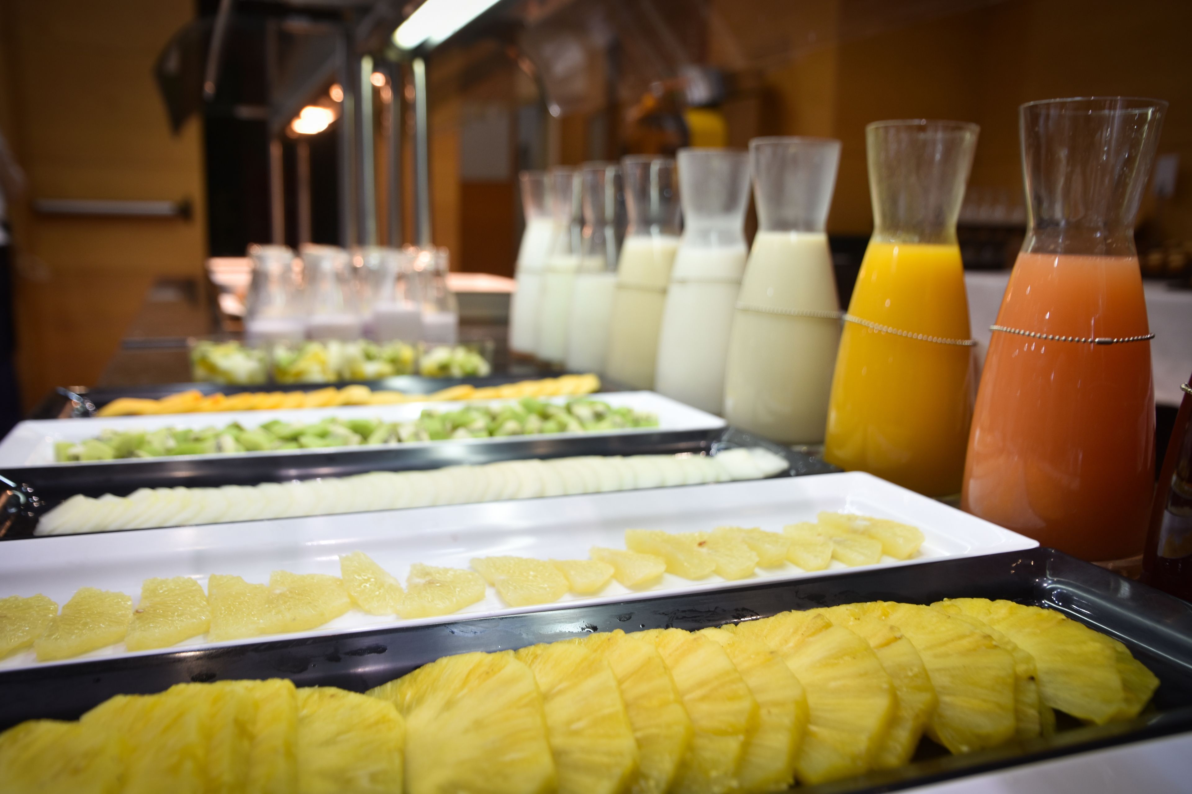 Un bufé con diversas frutas y bebidas.