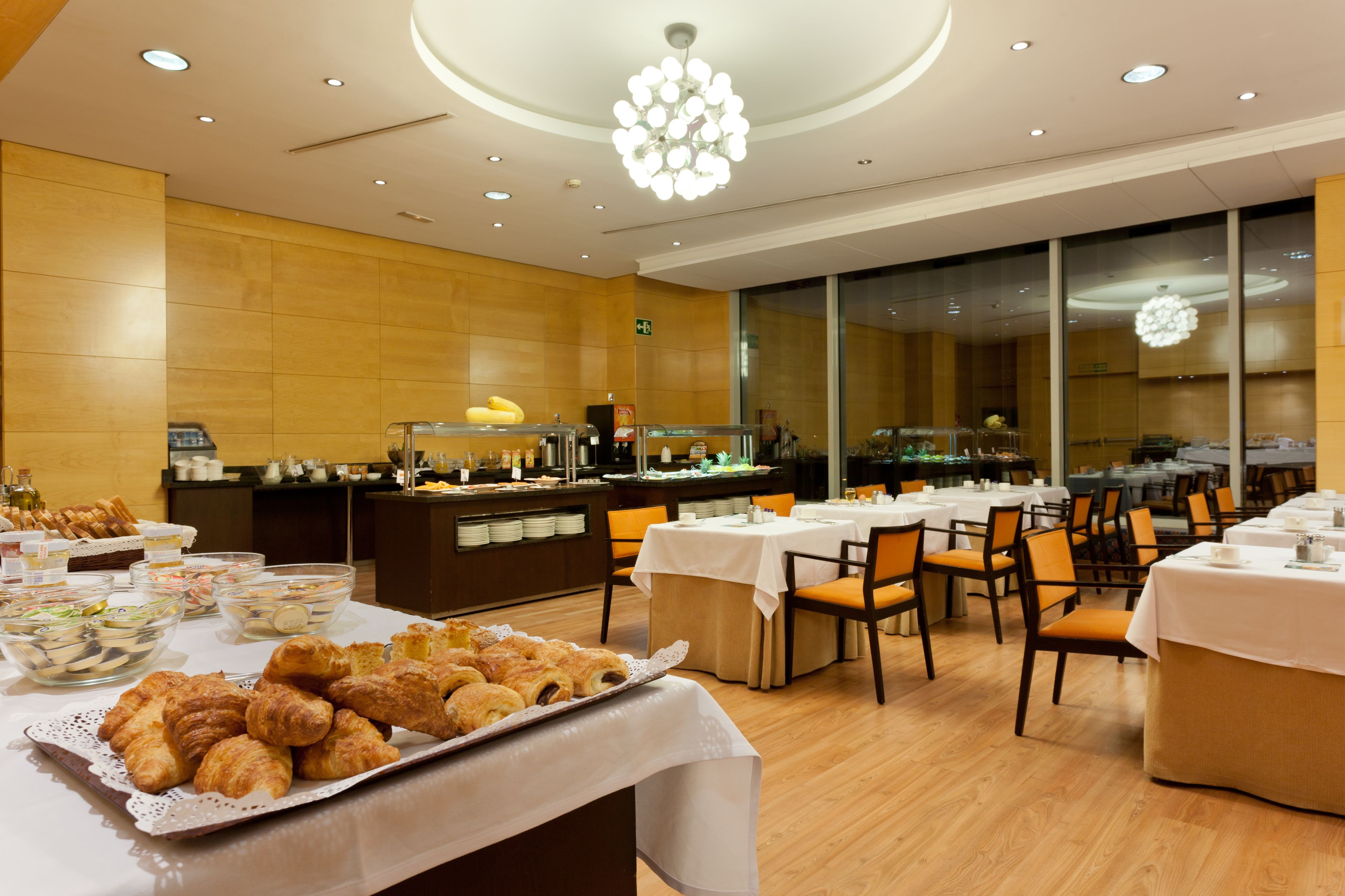 A buffet setup with various food items, tables, and chairs arranged in a dining area.