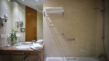 Une salle de bain moderne équipée d’un lavabo, d’un miroir, d’un porte-serviettes et d’une douche.