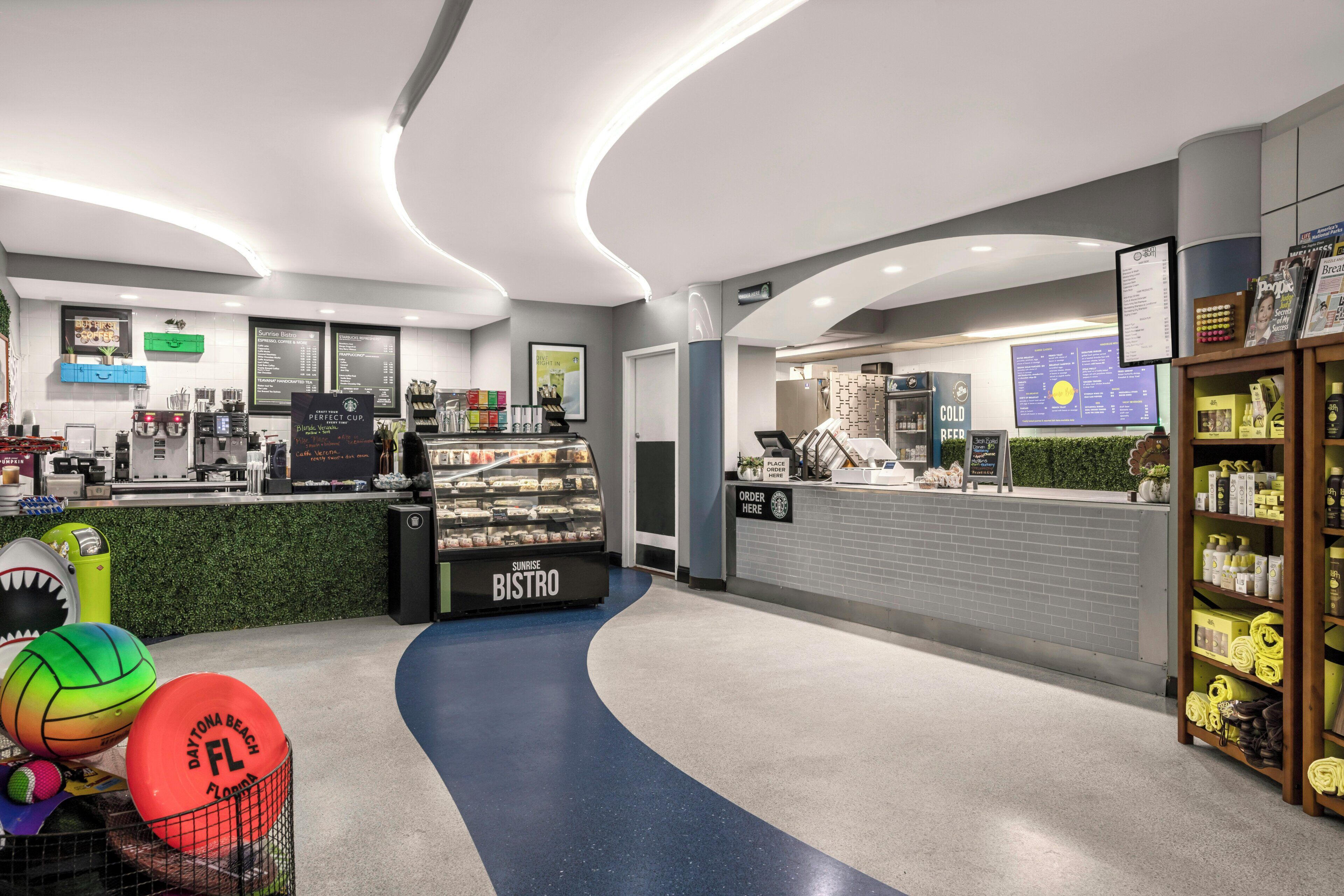 A modern bistro with a counter, menu boards, and a sports-themed decor.