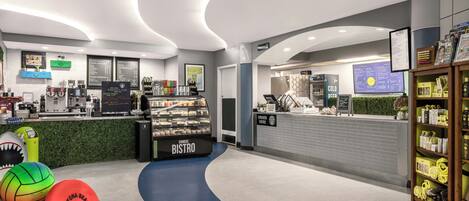 A modern bistro with a counter, menu boards, and a sports-themed decor.
