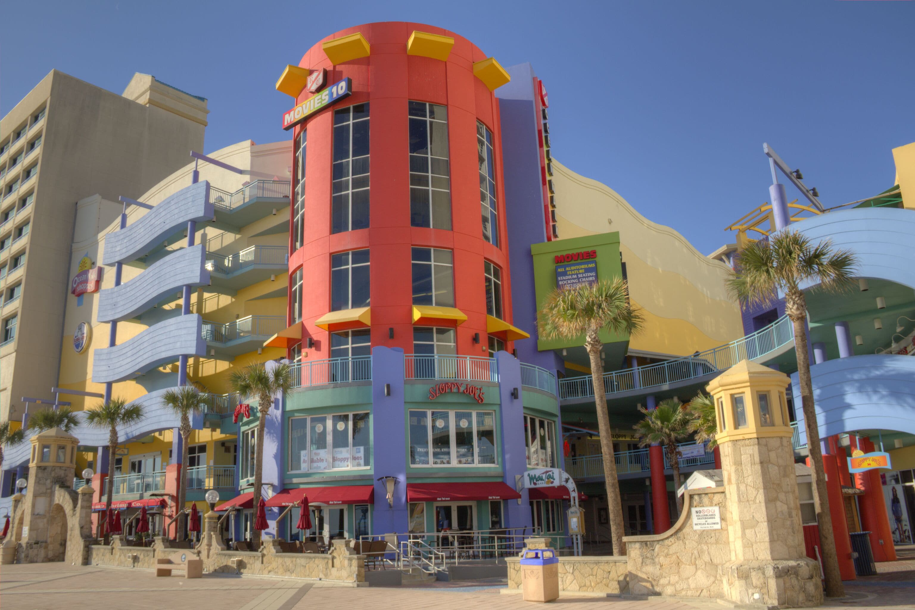 A colorful building with multiple balconies and a sign for 'Movies 10'.