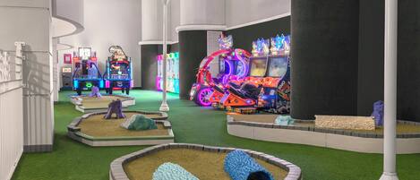 A gaming arcade with neon lights and various gaming machines.