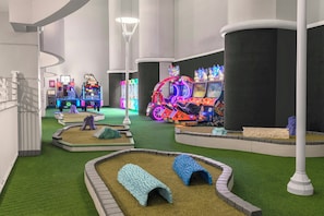 A gaming arcade with neon lights and various gaming machines.