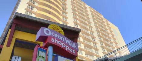 A multi-story building with a sign for Ocean Walk Shops and a sign for Johnny Rockets.