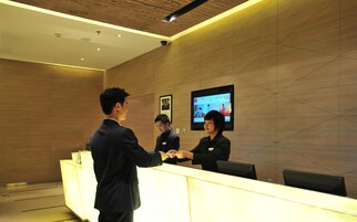 A reception area with a reception desk, a mounted television, and a security camera on the ceiling.