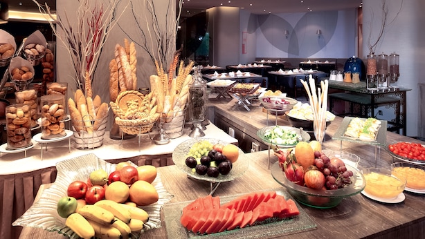 A buffet with various food items including fruits, vegetables, and bread. - Novotel Shenzhen Watergate (Shenzhen)