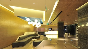 A modern lobby with a reception desk, seating area, and a large chandelier. - Novotel Shenzhen Watergate (Shenzhen)