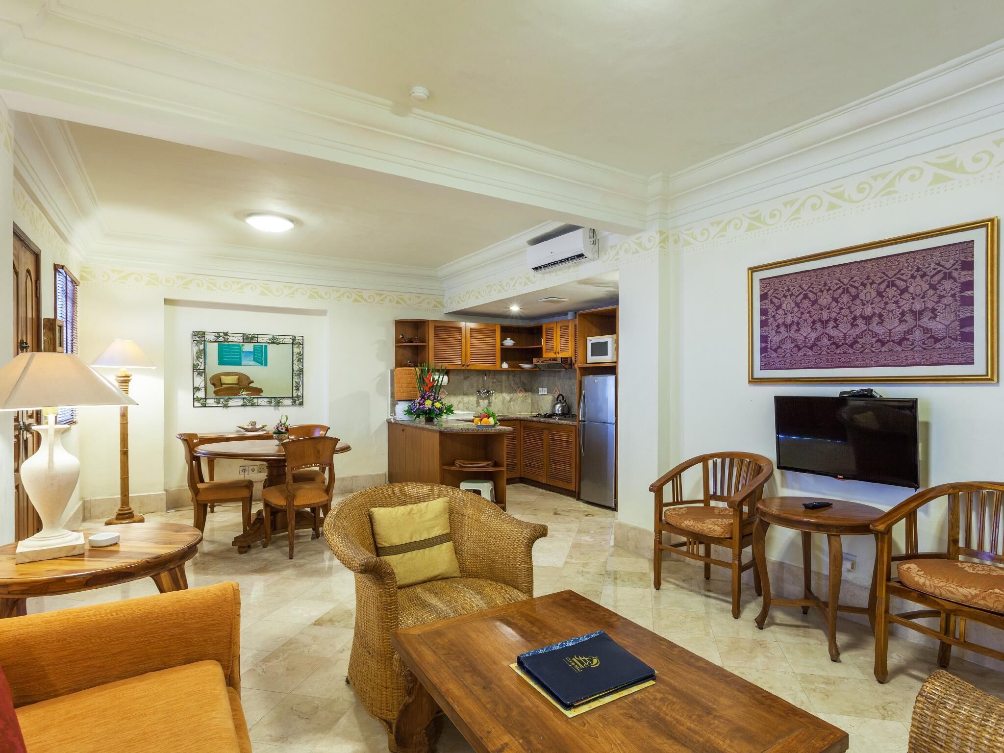 A spacious living room with a dining area, kitchen, and a TV.