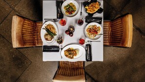 Vista cenital de una mesa de comedor con cuatro sillas, cada una con asiento y respaldo acolchados.