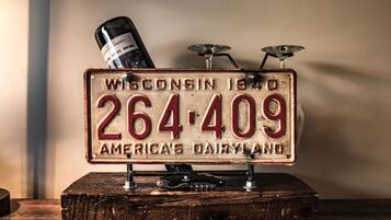 A vintage license plate with the text "Wisconsin 1940 264-409 America's Dairyland" mounted on a wooden base.