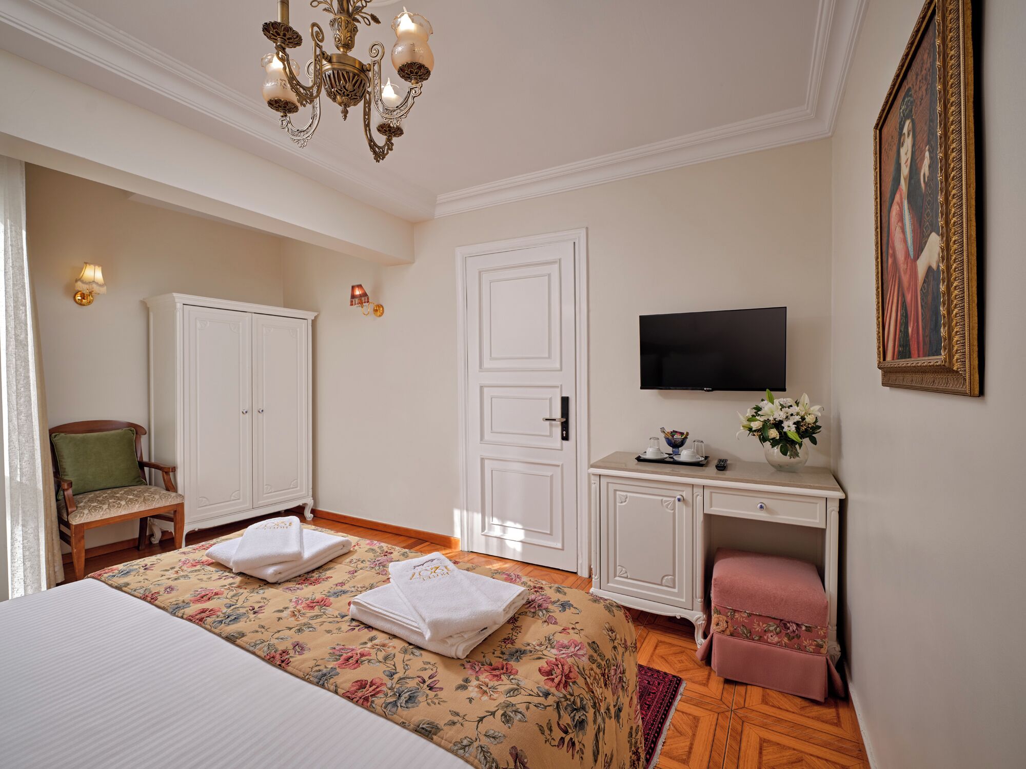 Ein Hotelzimmer mit Bett, Schreibtisch, Fernseher, Stuhl und Kleiderschrank.