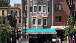 Un hotel con un letrero que dice "HOTEL 1907 Special Class" y un escaparate con toldo verde.