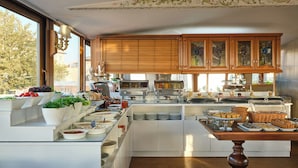 Una cocina moderna con una isla central, armarios de madera y vistas a árboles.