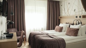 A hotel room with a bed, a desk, a chair, and a TV mounted on the wall. - Bosön Hotell & Konferens (Lidingo)