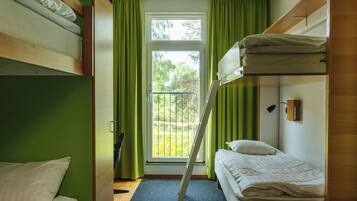 Un dormitorio con literas, una ventana con cortinas y vistas a zonas verdes.