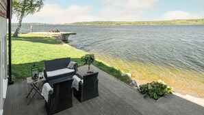 An outdoor patio with wicker furniture, a small table, and a lantern. - Bosön Hotell & Konferens (Lidingo)