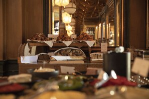 Disposição de buffet com diversos tipos de comida e ambiente iluminado por velas.