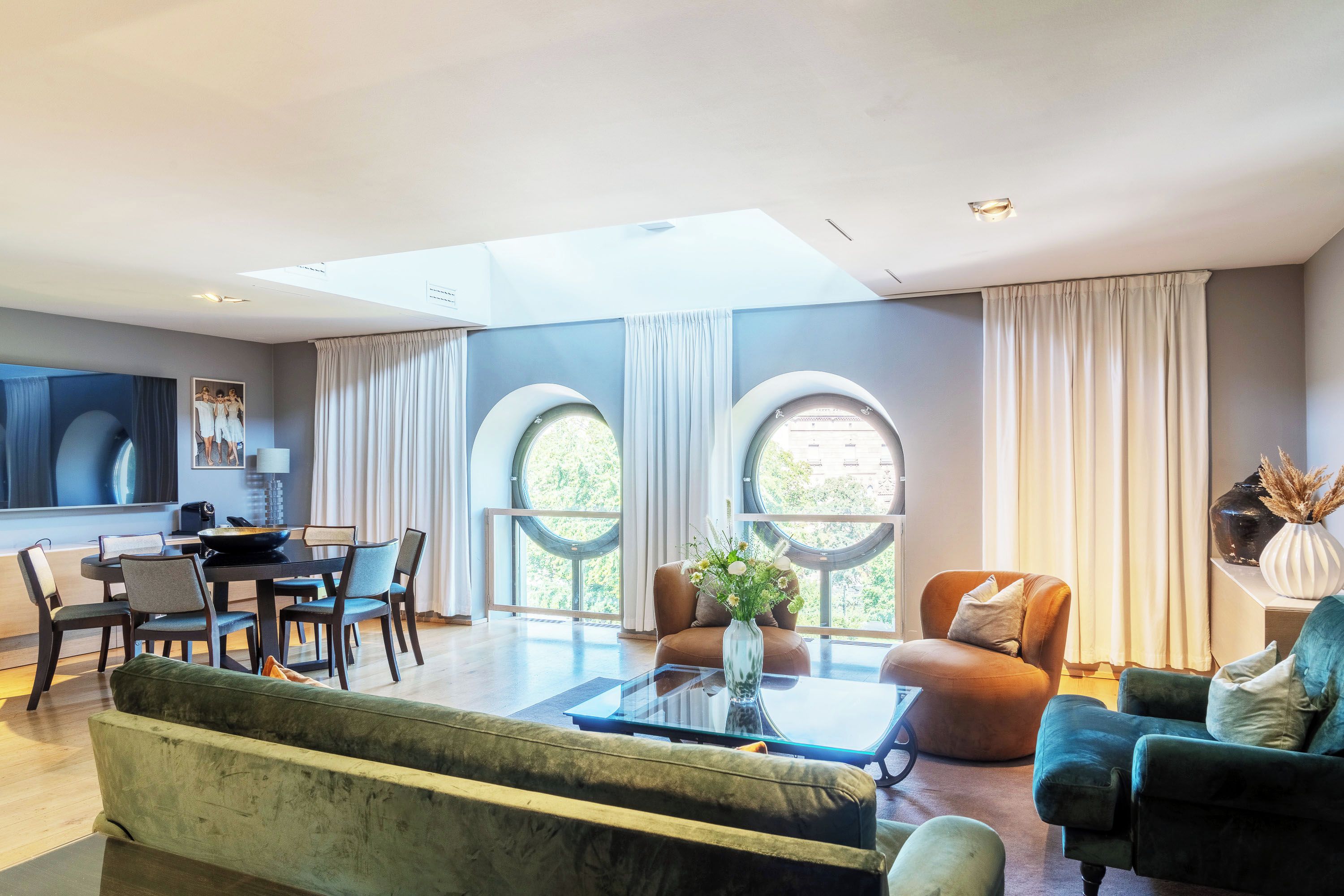 Un salón espacioso con comedor, ventanas amplias y un diseño moderno.