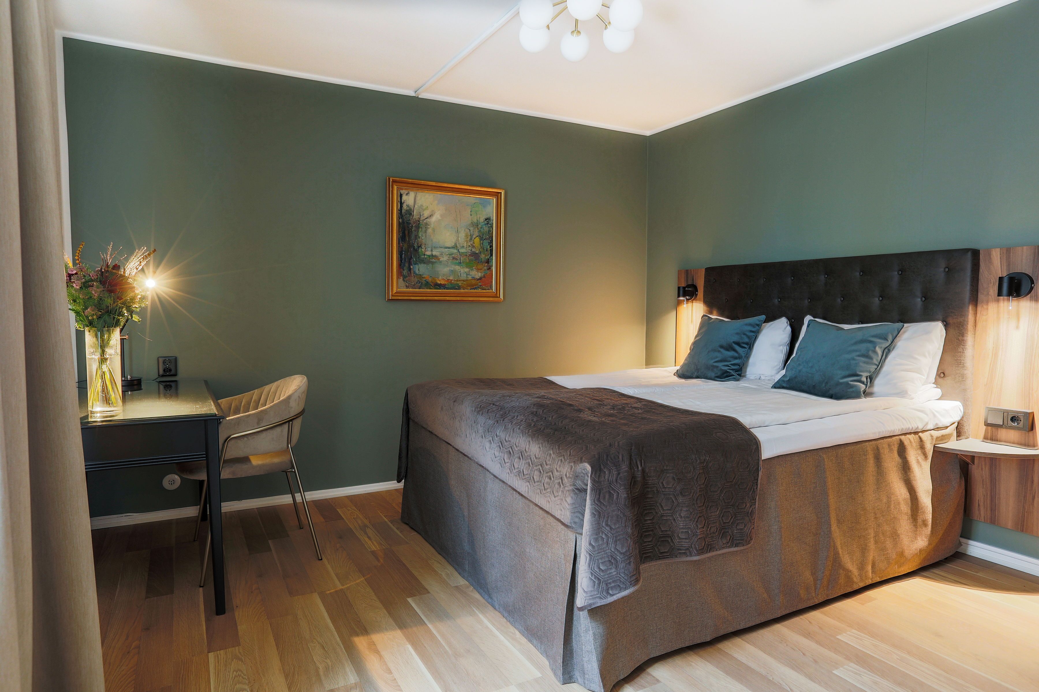 A bedroom with a bed, a desk, and a chair.