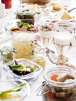 Diversos alimentos en recipientes de vidrio sobre una mesa.