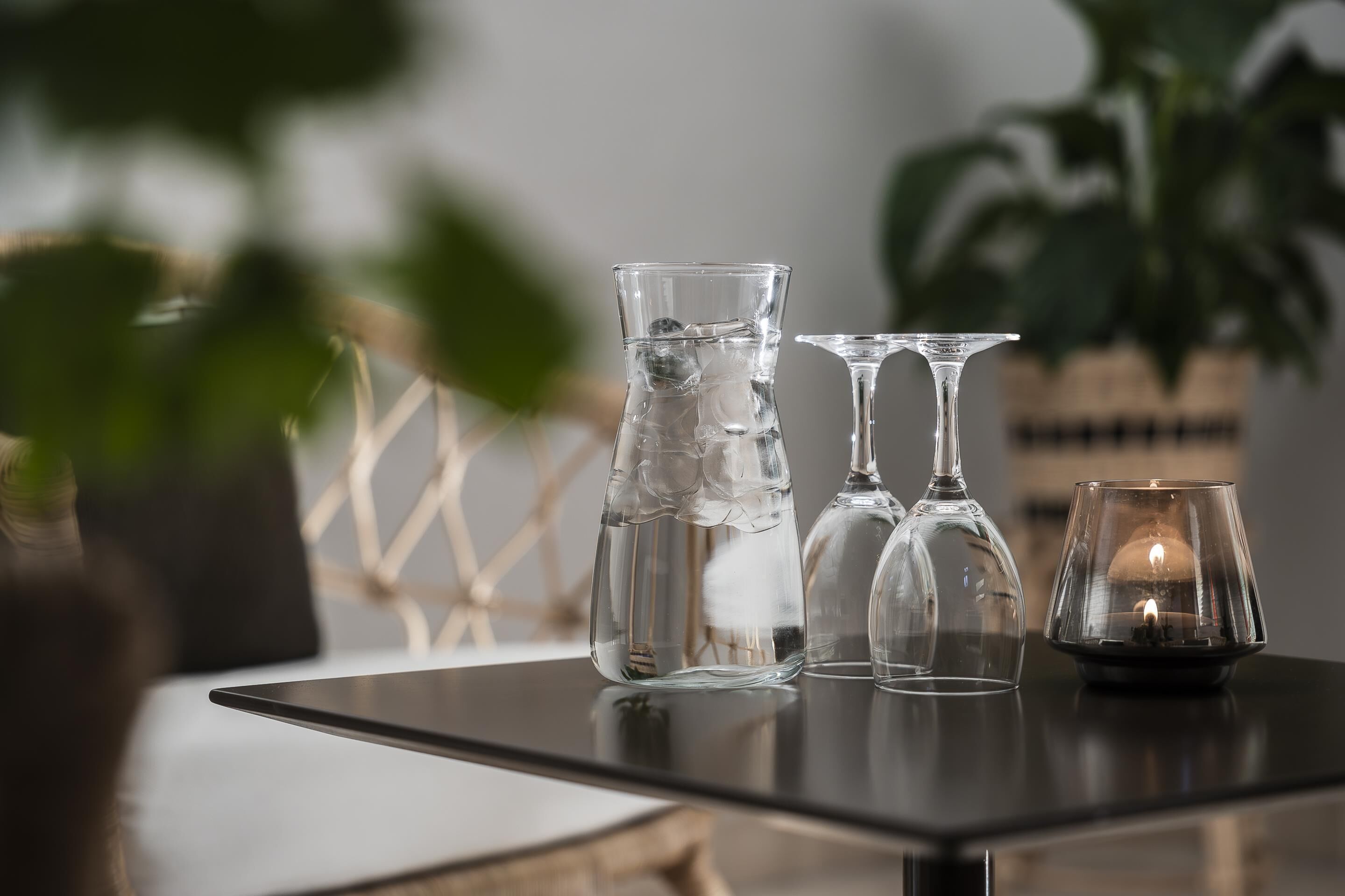 A table with three clear glass bottles and a candle holder.