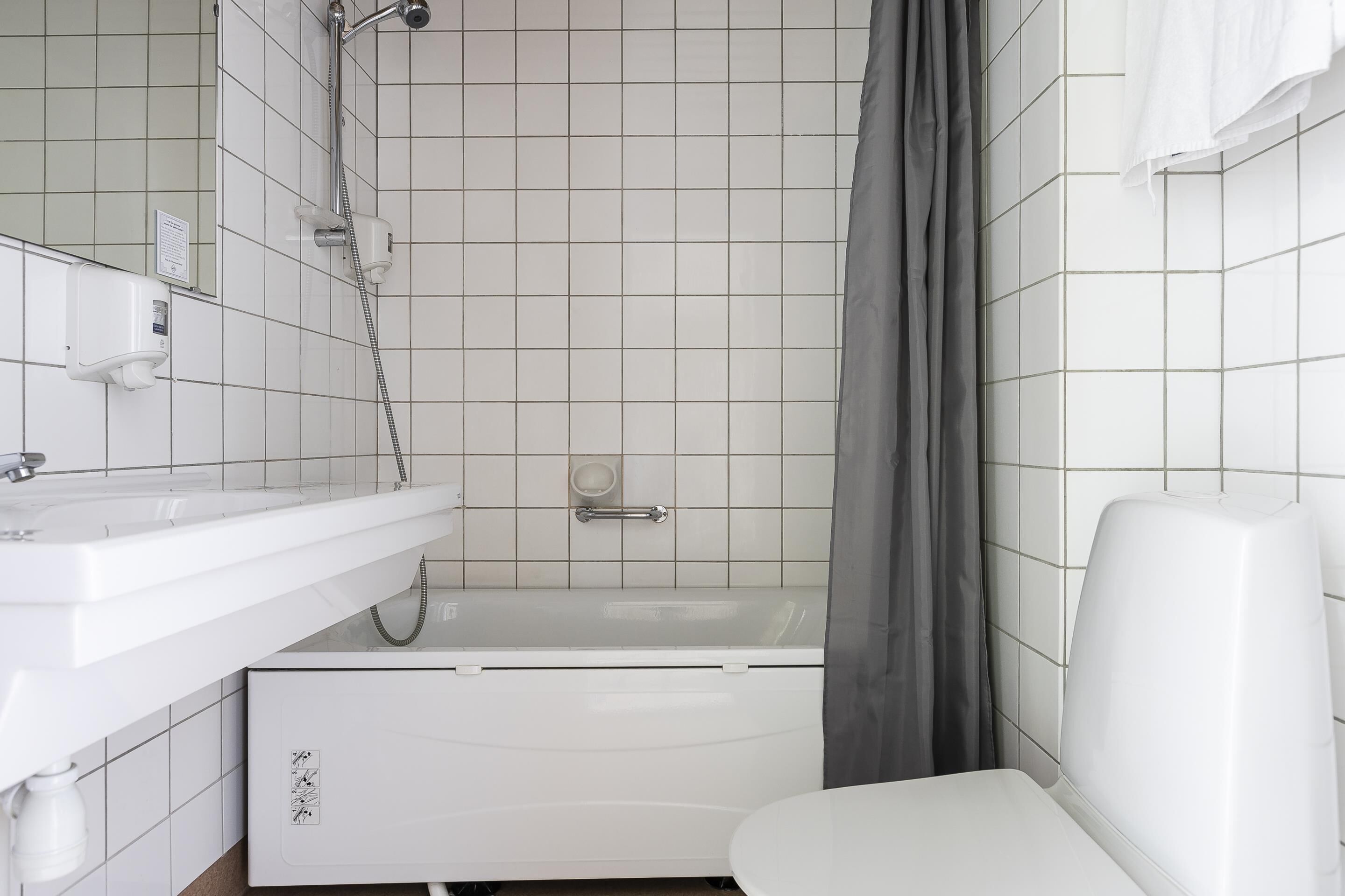 A bathroom with a white sink, a bathtub, and a toilet.