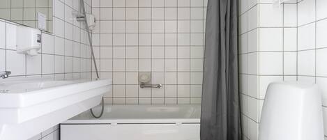 A bathroom with a white sink, a bathtub, and a toilet.