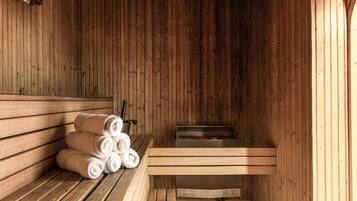 A sauna with wooden benches, a towel rack, and a steam room.