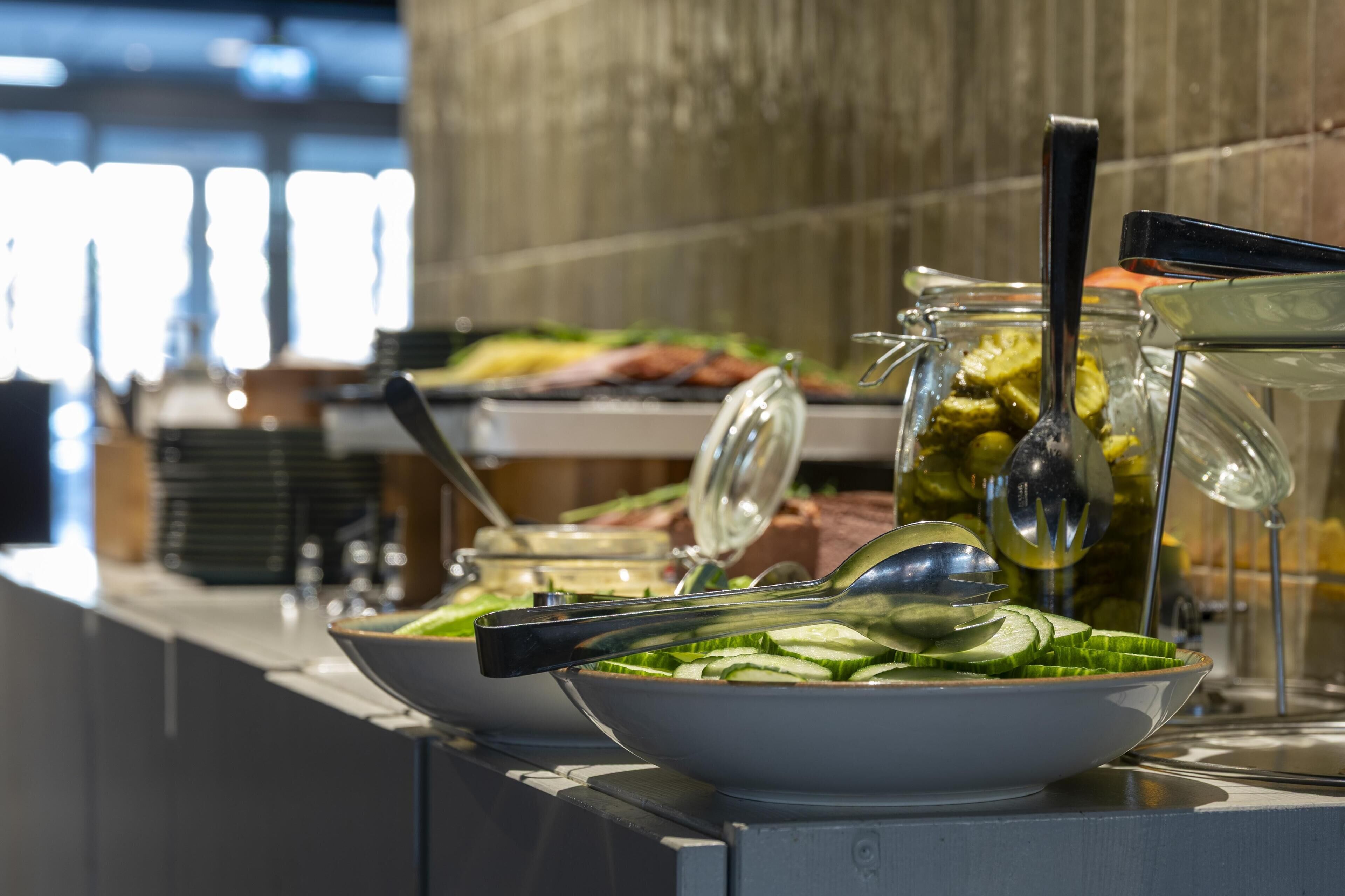 Una barra de buffet con diferentes alimentos y utensilios.