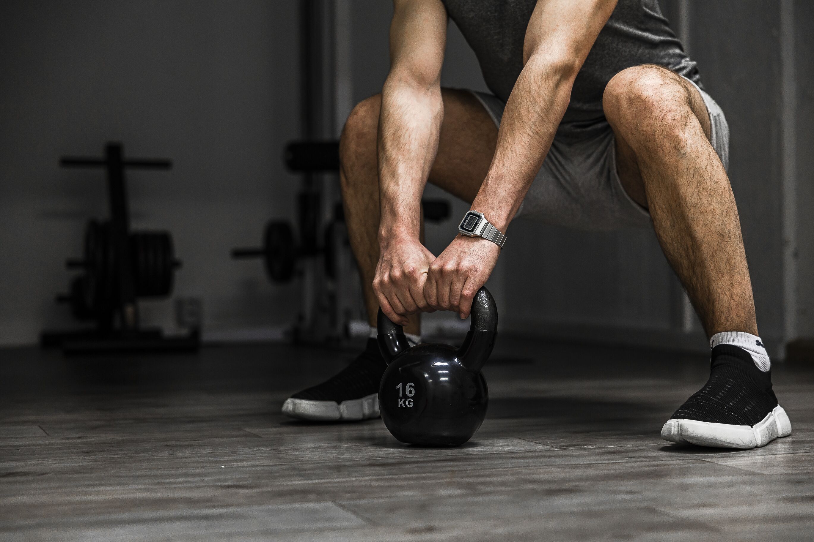 A person performing a kettlebell exercise with a 16 kg weight.