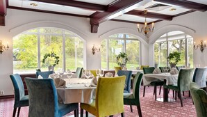A dining area with tables set for four, each with a white tablecloth and green chairs. - Best Western Royal Star (Älvsjö)