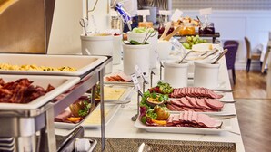 A buffet table with various food items including meats, cheeses, and salads. - Hotel Royal (Gothenburg)