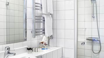A modern bathroom with a white sink, mirror, and shower.